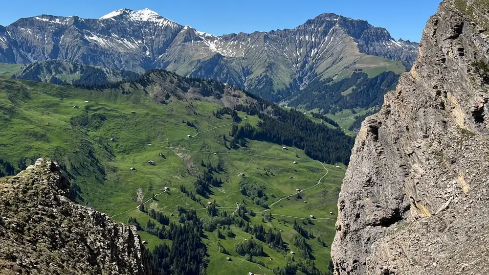 High alpine mountain pass with a winding road and snow-capped peaks, the kind of high-road day families plan for Sinthan Top